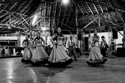 Apresentação de dança folclórica com temática do boi em ambiente rústico