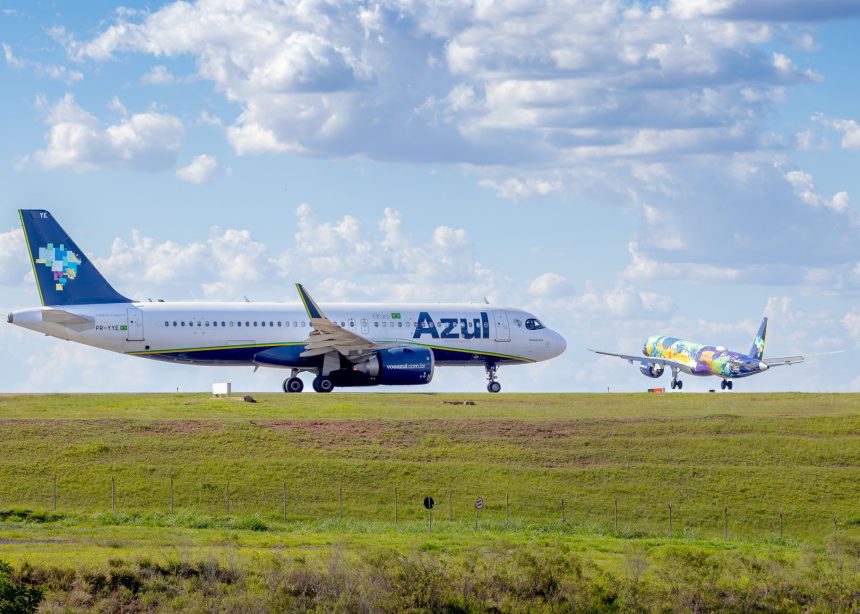 Aeronaves da Azul posicionadas em um aeroporto sob céu azul.